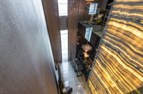Een stijlvolle luxe design cinewall in een moderne woonkamer, met een elektrische haard en decoratieve woonaccessoires.